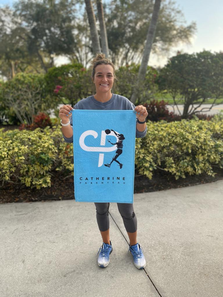 Catherine Parenteau pro pickleball player holding CP logo pickleball towel garden in background